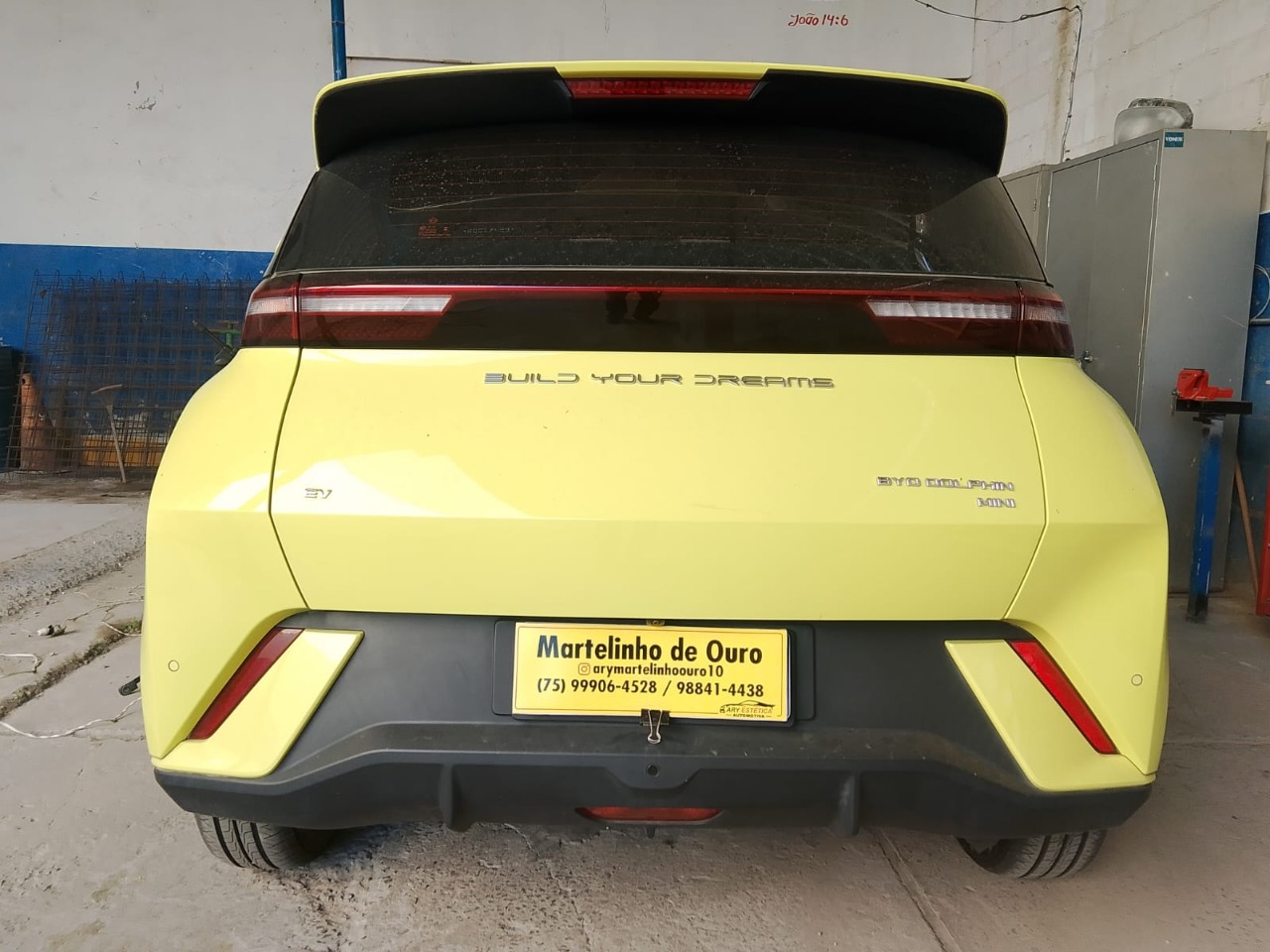 Traseira de veículo amarelo com placa da Martelinho de Ouro